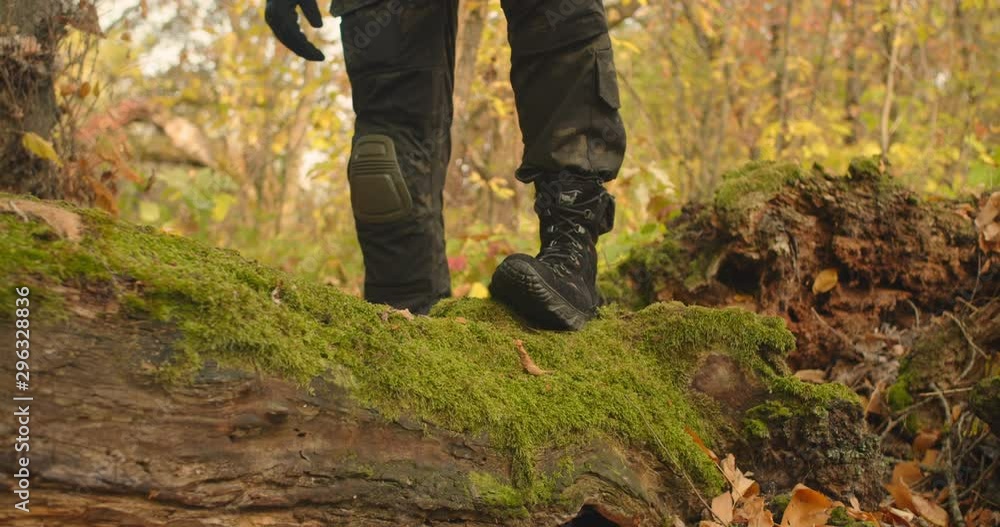 Mans legs dressed in military camouflage clothes and boots stepping and walking at around green landscape beautiful forest location, Sunny day travel concept Mans legs dressed in military camouflage clothes and boots stepping and walking at around green landscape beautiful forest location, Sunny day travel concept