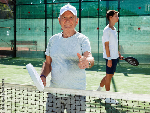  padel players of different generations posing on padel court