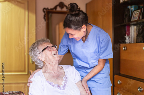 Happy Senior woman laughing. with her caregiver at home. Senior home care concept.