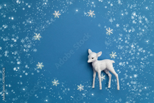 Festive Christmas background with a white deer, snowflakes and garland lights.