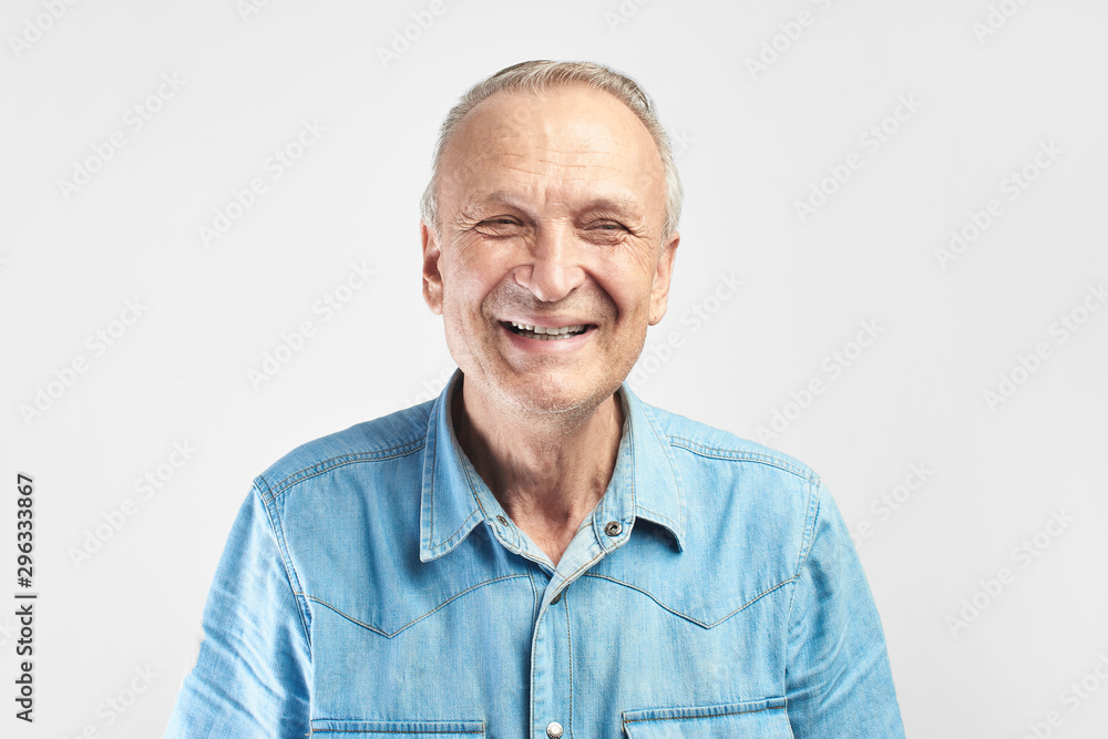 Portrait of a Caucasian elderly man smiling on a white studio background. Handsome gray-haired old pensioner with a friendly kind face Portrait of a Caucasian elderly man smiling on a white studio background. Handsome gray-haired old pensioner with a friendly kind face