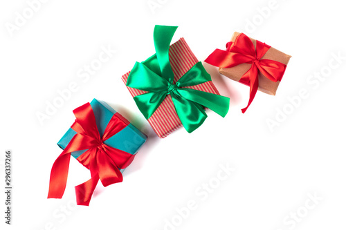 Bright christmas gifts with colorful atlas ribbons isolated on white
