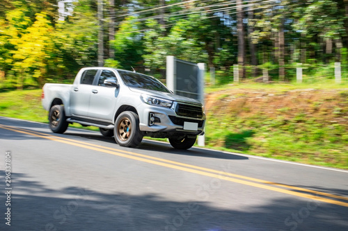 Blurry speedy movement of pickup truck driving on road photo