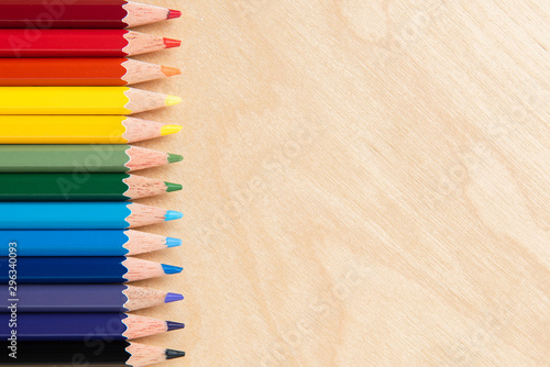 Colored pencils on wooden background