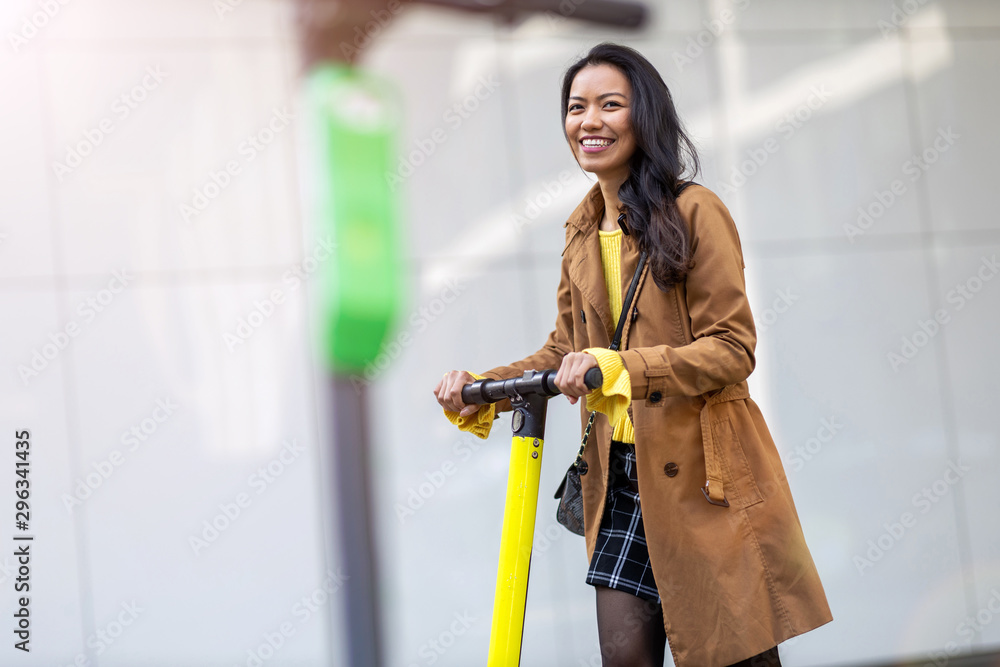 Fototapeta premium Female commuter riding electric push scooter 