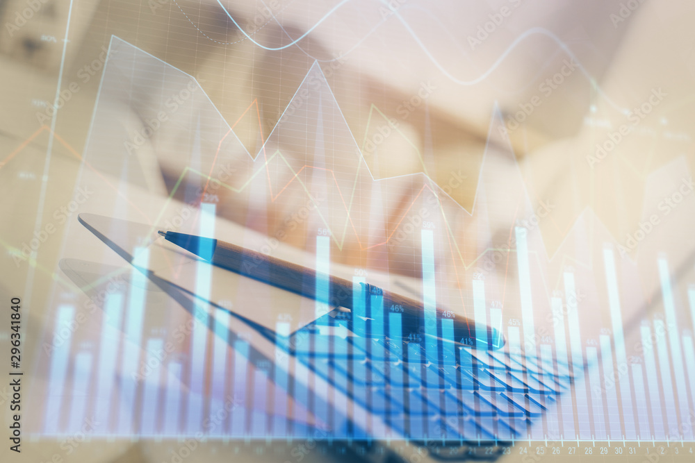 Stock market chart hologram drawn on personal computer background. Multi exposure. Concept of investment. Stock market chart hologram drawn on personal computer background. Multi exposure. Concept of investment.