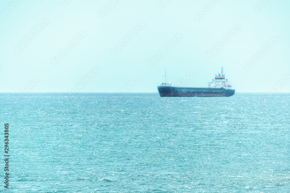 Blue water and transport ship in the sea on the horizon