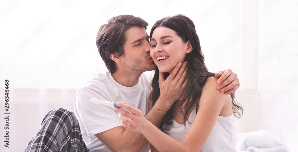 Enamoured couple finding out positive results of pregnancy test Enamoured couple finding out positive results of pregnancy test