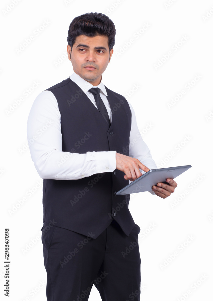 Handsome young businessman using digital tablet. Male entrepreneur is preparing presentation on wireless computer. He is wearing formals on white background. Handsome young businessman using digital tablet. Male entrepreneur is preparing presentation on wireless computer. He is wearing formals on white background.