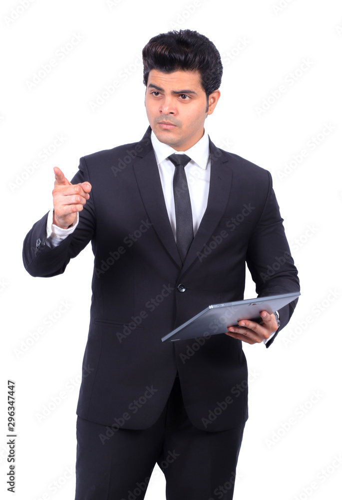 Confident young businessman pointing while holding digital tablet on white background Confident young businessman pointing while holding digital tablet on white background