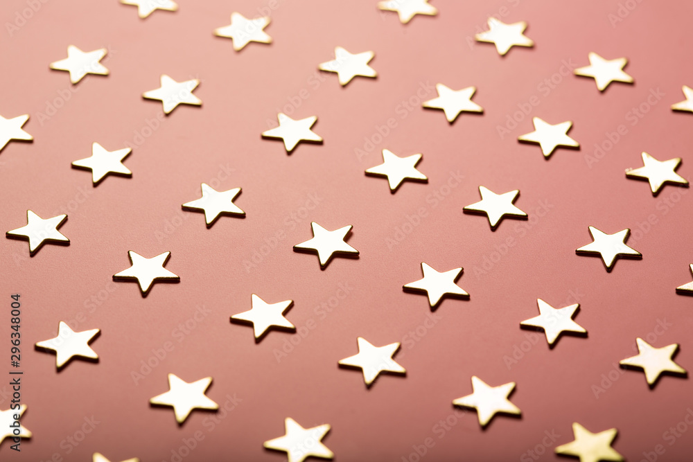 Festive composition with golden stars on dusty pink background Festive composition with golden stars on dusty pink background