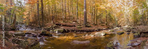 A river in the mountains with stones in autumn as a panorama