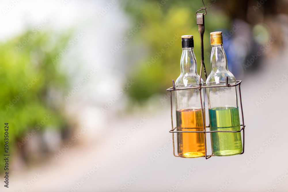 Petrol /gasoline for sale on the street in reused glass bottles. Glass bottles with gasoline hang near the store. Petrol /gasoline for sale on the street in reused glass bottles. Glass bottles with gasoline hang near the store.