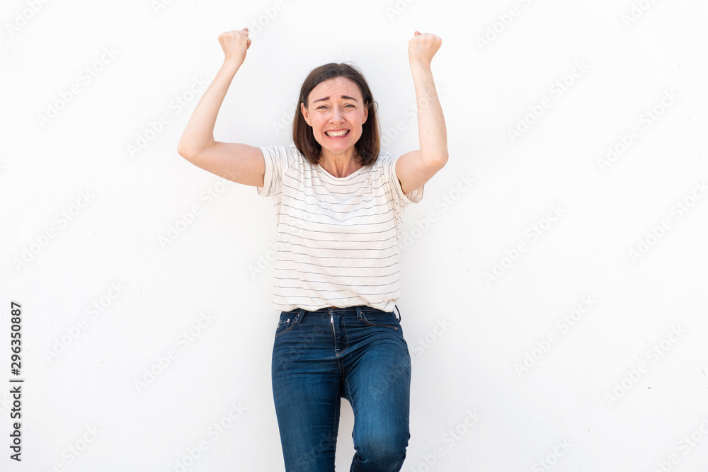 older woman cheering with fist pump by white background older woman cheering with fist pump by white background