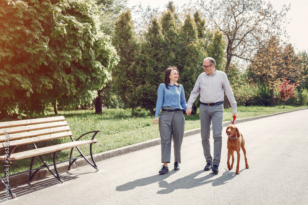 Couple in a forest. Adult pair with cute dogs. Lady in a blue shirt Couple in a forest. Adult pair with cute dogs. Lady in a blue shirt