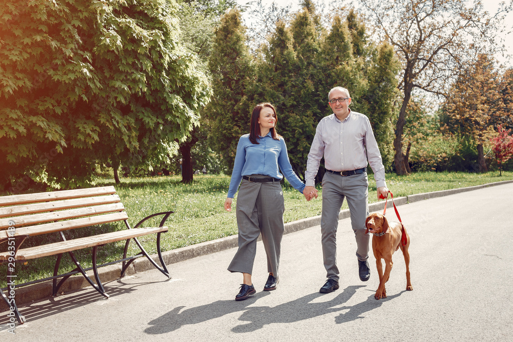 Couple in a forest. Adult pair with cute dogs. Lady in a blue shirt Couple in a forest. Adult pair with cute dogs. Lady in a blue shirt