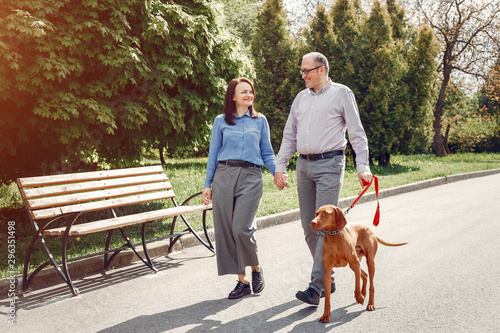 Couple in a forest. Adult pair with cute dogs. Lady in a blue shirt