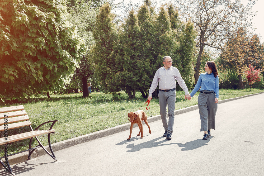 Couple in a forest. Adult pair with cute dogs. Lady in a blue shirt Couple in a forest. Adult pair with cute dogs. Lady in a blue shirt