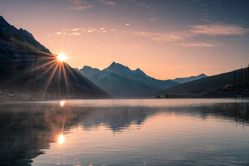 Foto auf Leinwand Schlafzimmer Sonnenaufgang am Berg mit Nebel im Medizinsee bei Jasper  © Mumemories