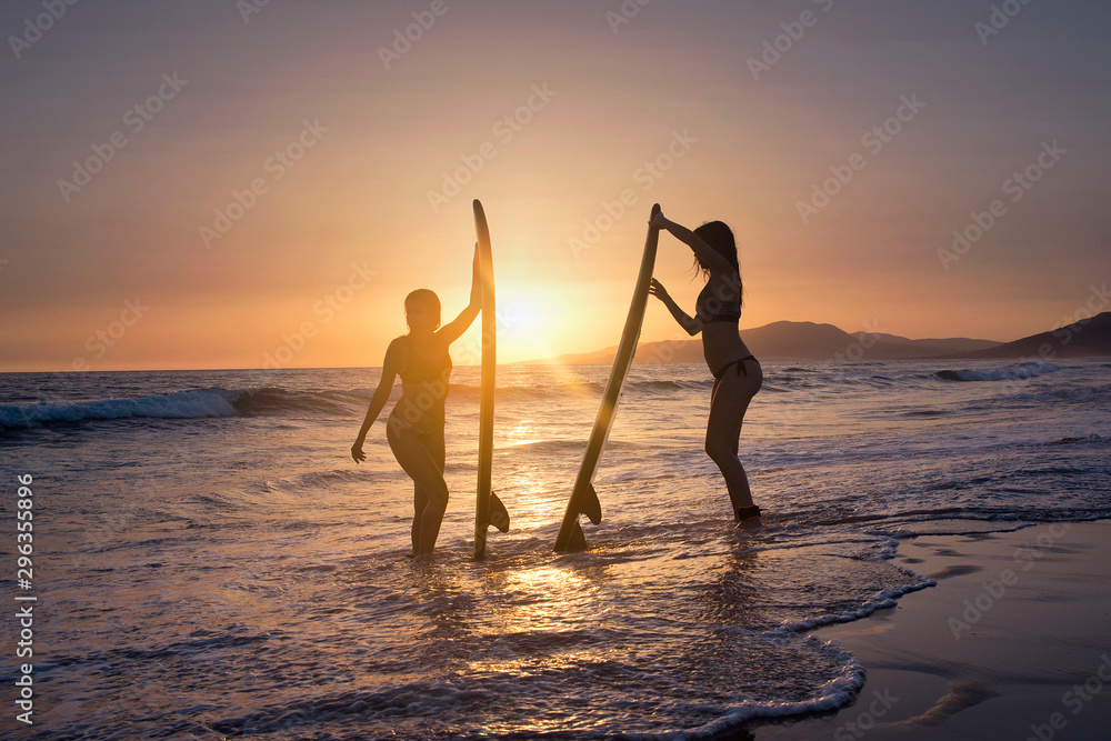 Sexi surfer girls posing on the beach at sunset, Tarifa, Cadiz, Andalucia, Spain