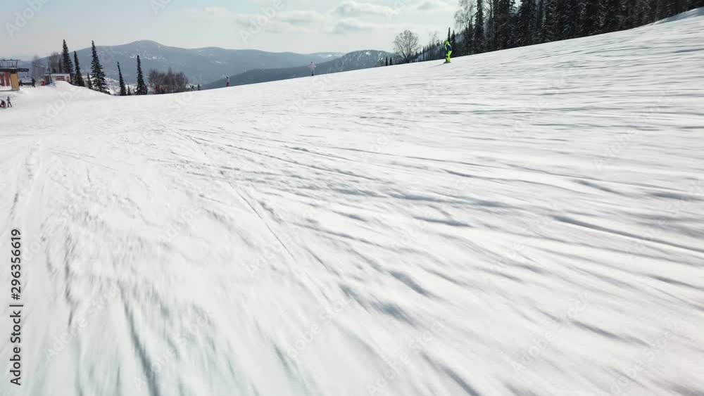 Young adult recreational skier enjoys idyllic perfect weather in cold winter. Skiing alone on perfectly groomed ski piste at ski resort Young adult recreational skier enjoys idyllic perfect weather in cold winter. Skiing alone on perfectly groomed ski piste at ski resort