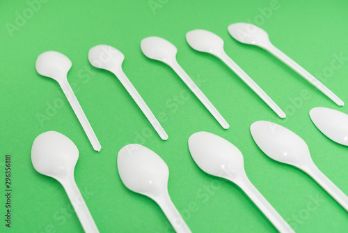 many plastic spoons on green background