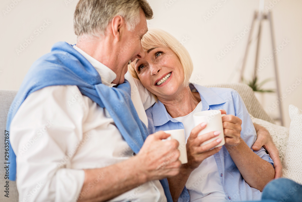 Loving mature couple enjoying morning tea at autumn day