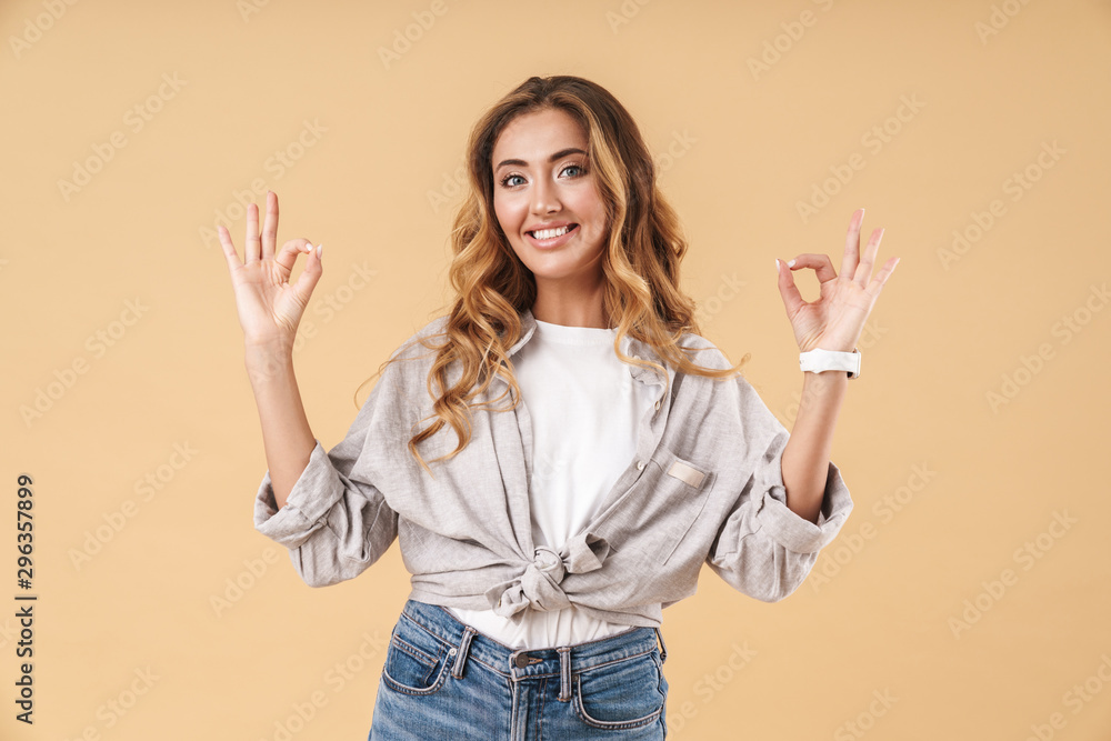 Portrait of beautiful woman smiling and showing ok sign with fingers Portrait of beautiful woman smiling and showing ok sign with fingers