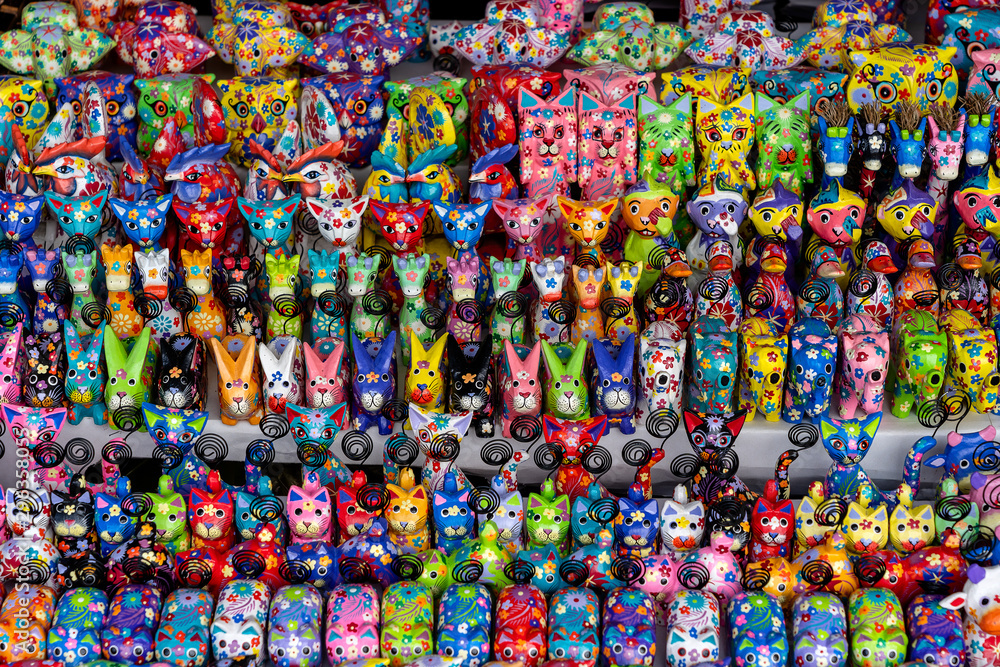 Sale of souvenirs - funny handmade wooden animals in street market. Bright colorful children toys and decoration for interior. Ubud, Bali island, Indonesia. Closeup