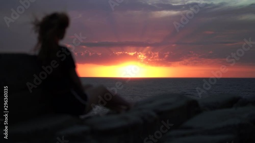 girl looking at an amzing sunset over the mediterranean sea in italy tuscany photo