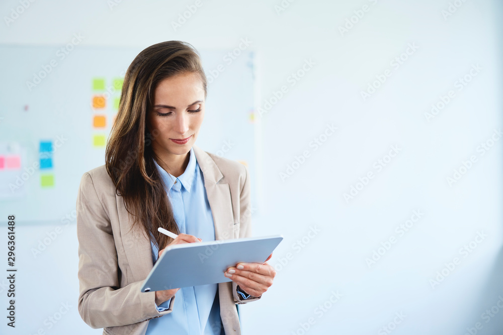 Young businesswoman writing on tablet in office Young businesswoman writing on tablet in office