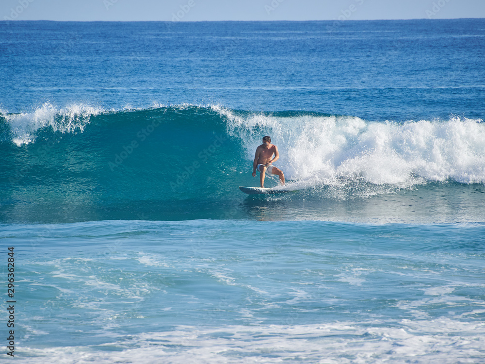A surfer rides along a big beautiful glassy wave. Wave of the Atlantic Ocean. Warm tropical water. A surfer rides along a big beautiful glassy wave. Wave of the Atlantic Ocean. Warm tropical water.