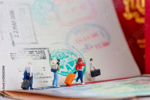 Miniature toys concept studio set up - a couple arrives or departs at an airport with the lady is talking to her mobile phone with visa passport stamps as the background. photo