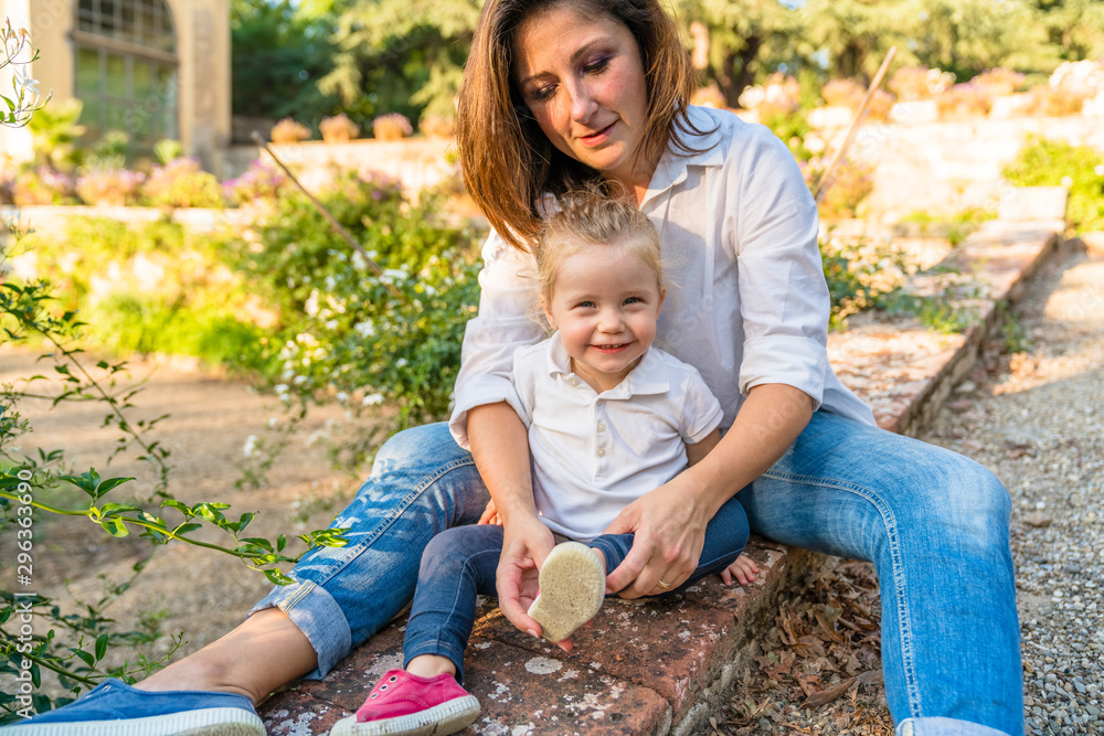 Portrait of little girl sitting in a park with her mother Portrait of little girl sitting in a park with her mother
