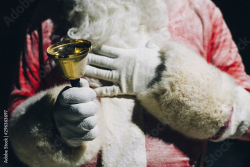 Hand of Santa Claus holding handbell, close-up photo