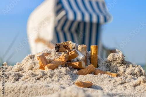 Zigarettenstummel im Sand vor Strandkorb
