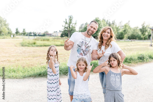 Happy parents with three triplet sisters posing outdoors