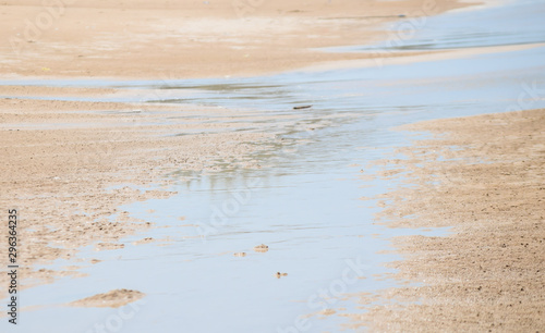 Beautiful sunlight reflect with water on sand beach