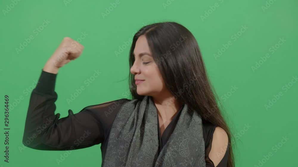 Woman Flexing Muscle Trying To Suggest Power. Studio Isolated Shot Against Green Screen Background Woman Flexing Muscle Trying To Suggest Power. Studio Isolated Shot Against Green Screen Background