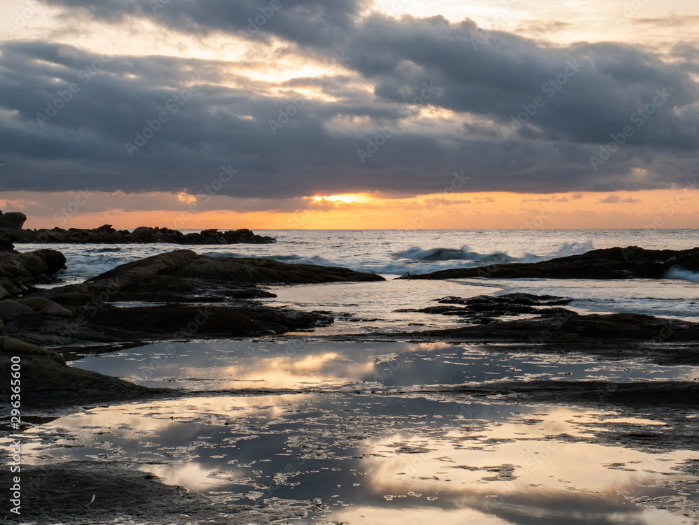 sunrise on rocky beach with orange light sunrise on rocky beach with orange light