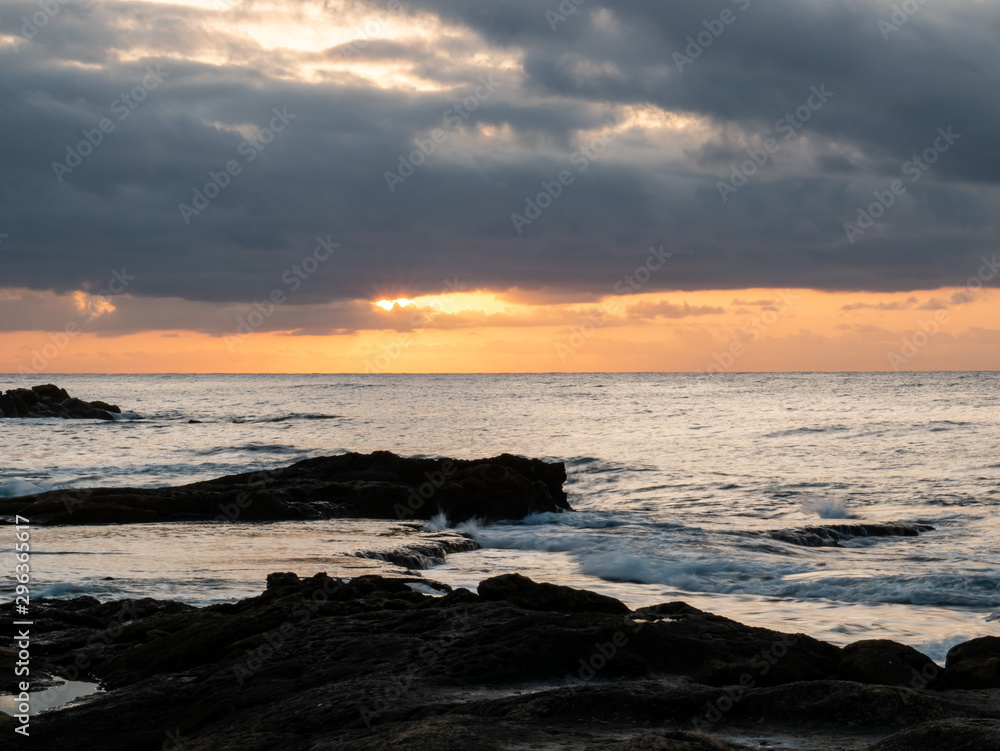  sunrise on rocky beach with orange light