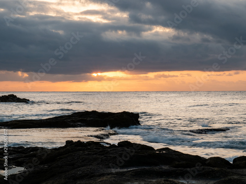  sunrise on rocky beach with orange light