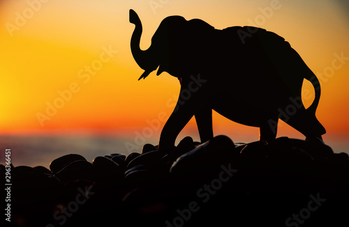 Silhouette of an elephant figurine on the background of the sea and the sunset sky. Balnce & Harmony.