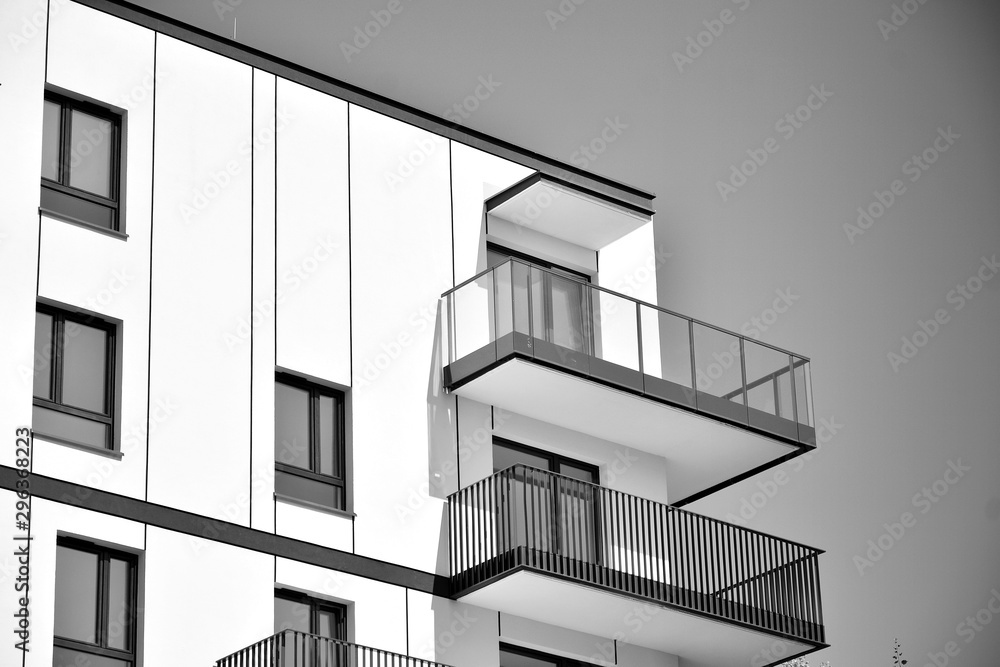 Fragment of a facade of a building with windows and balconies. Modern home with many flats. Black and white. Fragment of a facade of a building with windows and balconies. Modern home with many flats. Black and white.