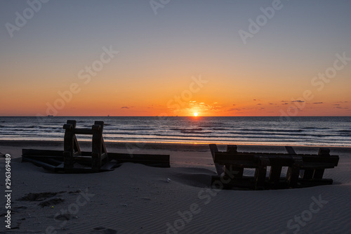 Fototapeta Naklejka Na Ścianę i Meble -  Silhouete of metal construction design like stool on the sea beach in beautiful sunset with serene sea in the background