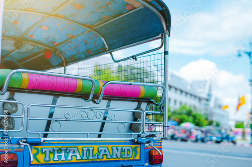 asia local travel in city activity with close up backside of local taxi (tuk tuk) with driver and tourism drive on street of bangkok Thailand with grandpalace landmark background photo