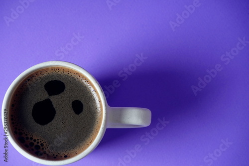 White Cup with black coffee on lilac background. Rest, relaxation, tone.