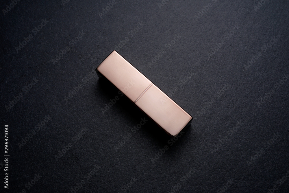 Bronze finished Lipstick make up on a dark slate stone background Bronze finished Lipstick make up on a dark slate stone background