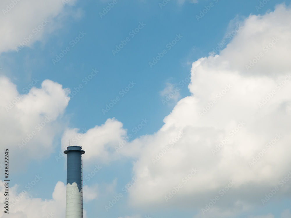 Blue and white chimney against blue sky with clouds Blue and white chimney against blue sky with clouds