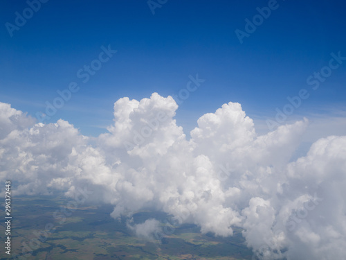 Clouds from airplane window with blue sky and high angle ground © Lucky7Trader